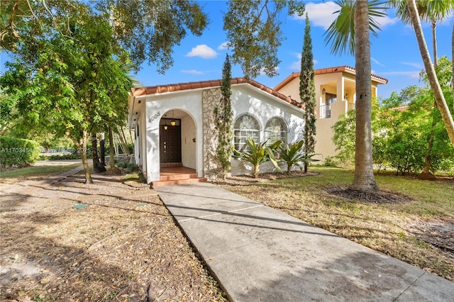 mediterranean / spanish house with a tile roof and stucco siding