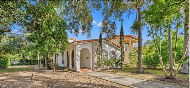 mediterranean / spanish home with a tile roof and stucco siding