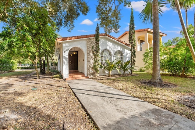 mediterranean / spanish home with a tiled roof and stucco siding