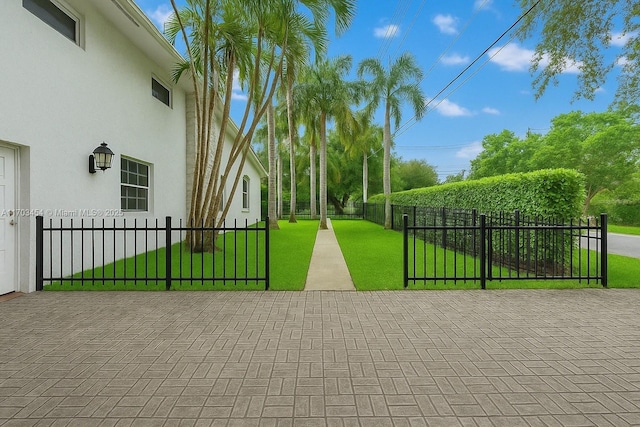 view of gate with a yard and a fenced front yard