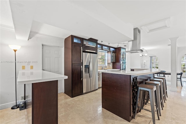 kitchen with a breakfast bar, a kitchen island, island range hood, and stainless steel appliances