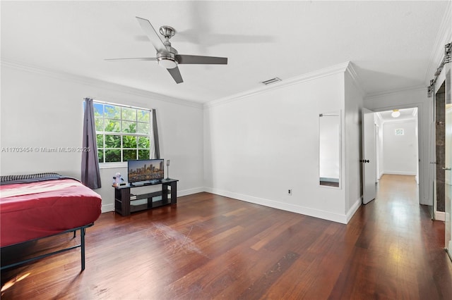 bedroom featuring wood finished floors, visible vents, baseboards, and ornamental molding