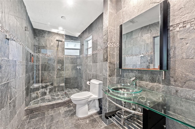 bathroom with toilet, tile walls, marble finish floor, a shower stall, and vanity