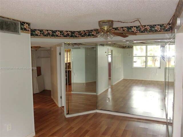 unfurnished room featuring a textured ceiling, hardwood / wood-style flooring, and ceiling fan