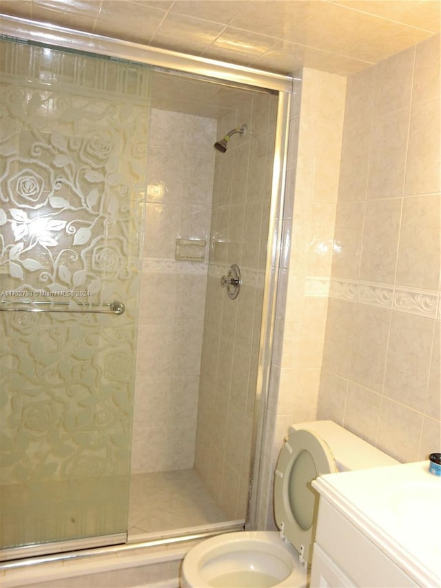 bathroom with vanity, a shower with shower door, and toilet