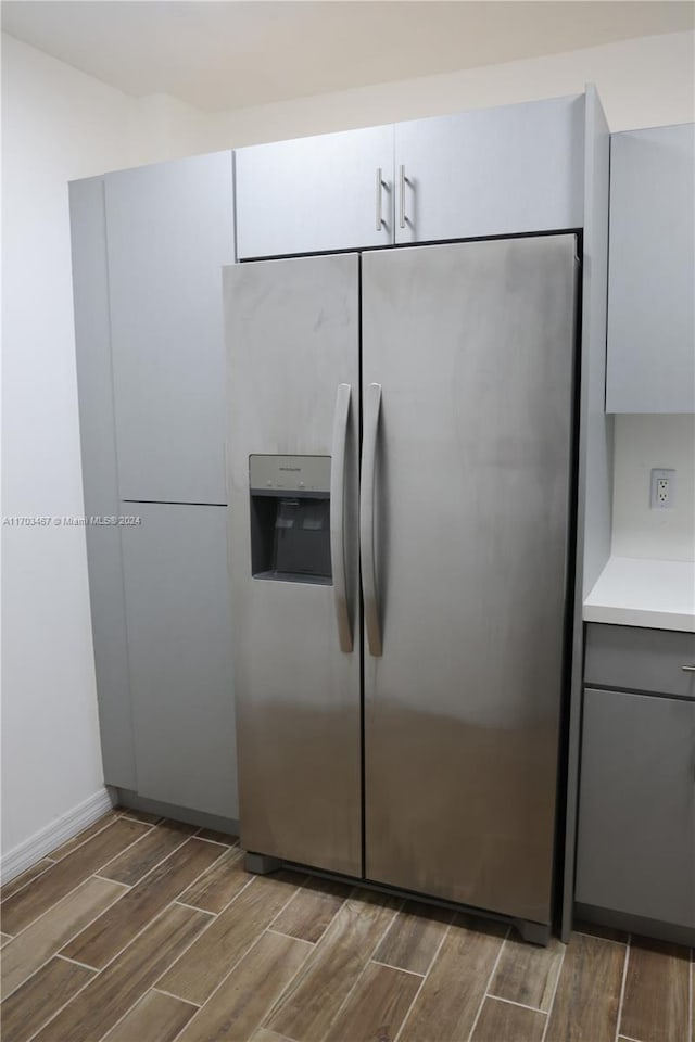 kitchen featuring stainless steel fridge, white cabinets, and dark hardwood / wood-style floors