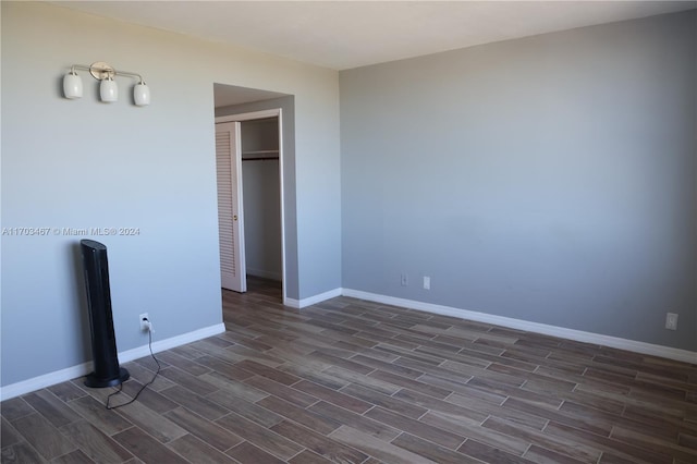 unfurnished bedroom featuring a closet and dark wood-type flooring