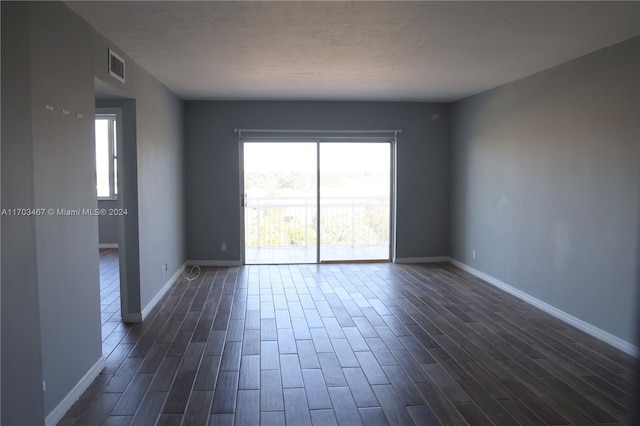 unfurnished room with dark hardwood / wood-style flooring