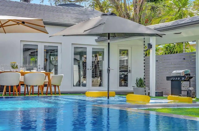 view of pool featuring area for grilling and french doors