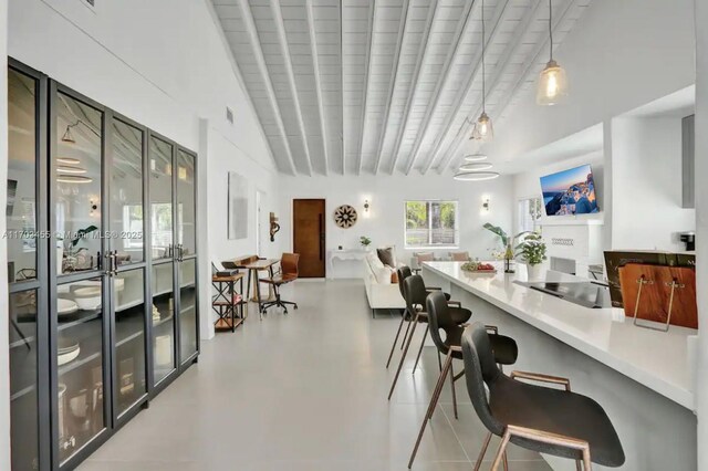 living room featuring beam ceiling and high vaulted ceiling