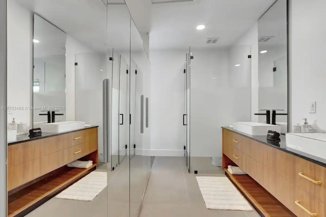 bathroom with tile patterned floors, vanity, and a shower with shower door