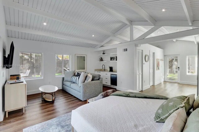 bedroom featuring hardwood / wood-style flooring, vaulted ceiling with beams, and sink