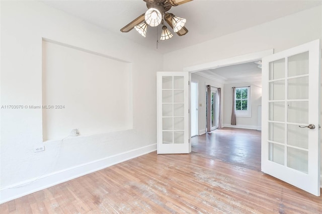 unfurnished room with crown molding, ceiling fan, french doors, and wood-type flooring