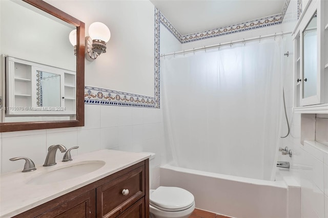 full bathroom with vanity, toilet, tile walls, tasteful backsplash, and shower / tub combo