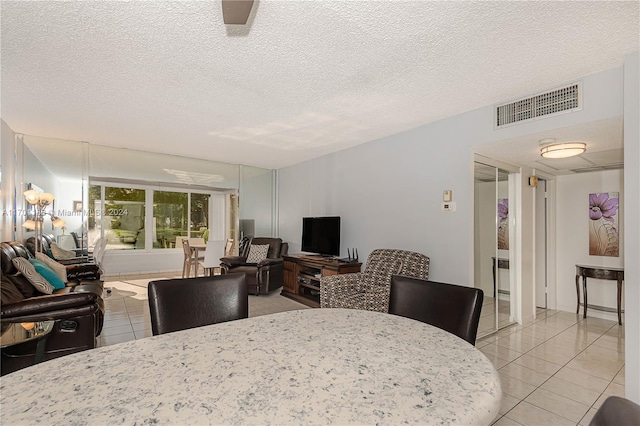 dining space featuring light tile patterned floors and a textured ceiling