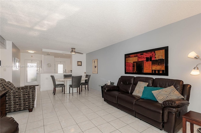 tiled living room with ceiling fan and a textured ceiling