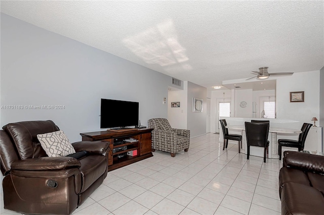 tiled living room with ceiling fan and a textured ceiling