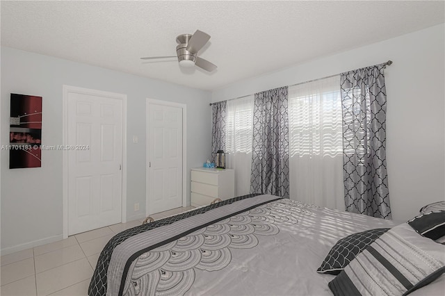 tiled bedroom featuring ceiling fan and a textured ceiling