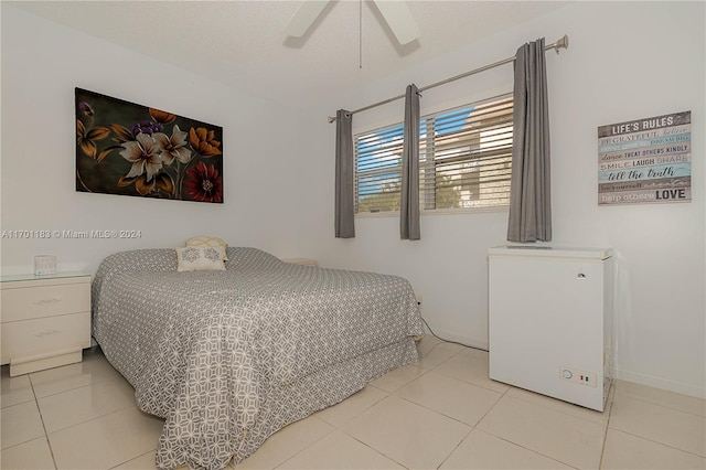 tiled bedroom featuring ceiling fan and refrigerator