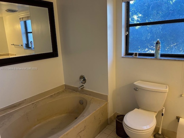 bathroom with tile patterned flooring, a bath, and toilet