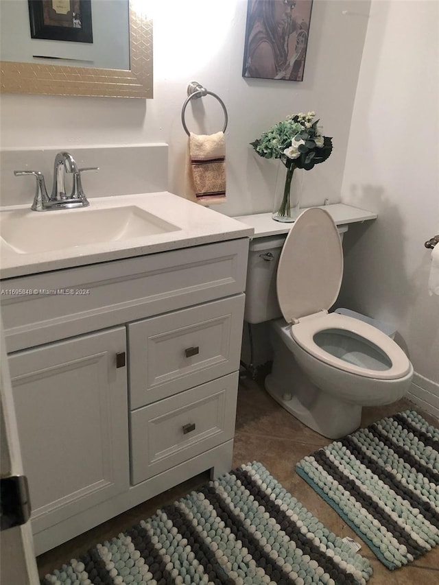 bathroom featuring tile patterned flooring, vanity, and toilet