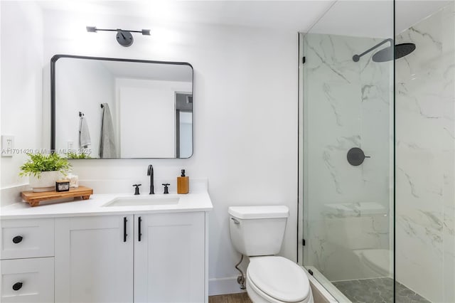 bathroom with vanity, toilet, and tiled shower