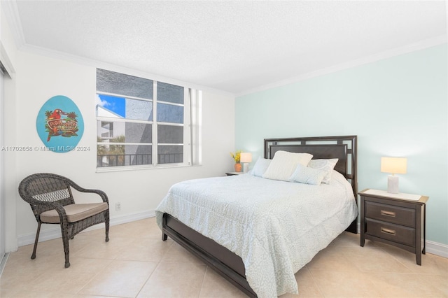 bedroom featuring light tile patterned floors, a textured ceiling, and ornamental molding