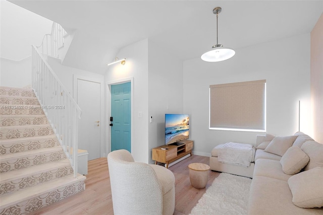 living room with light wood-type flooring and vaulted ceiling