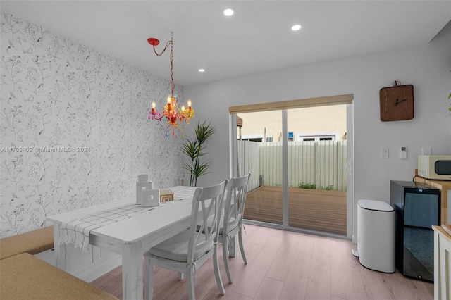 dining room with light wood-type flooring and an inviting chandelier