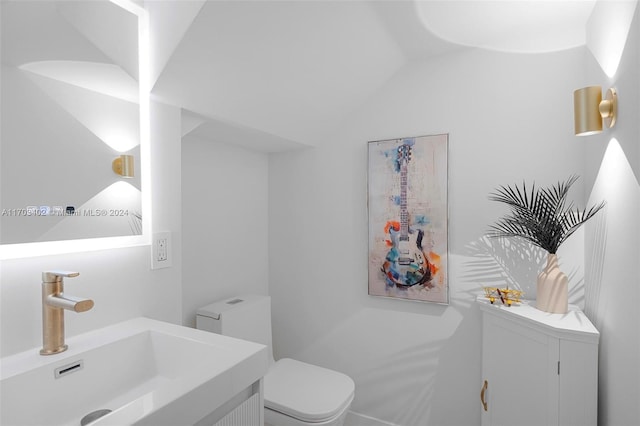 bathroom with vanity, vaulted ceiling, and toilet