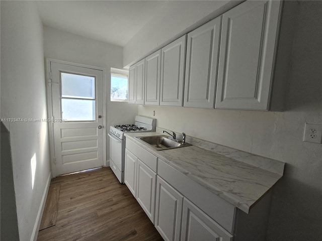 kitchen with dark hardwood / wood-style flooring, light stone counters, white range with gas cooktop, sink, and white cabinetry