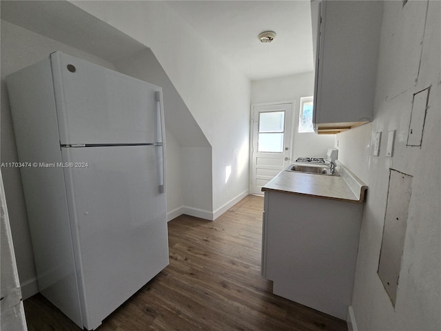 kitchen with dark hardwood / wood-style flooring, white refrigerator, and sink