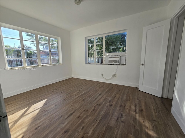 unfurnished bedroom with cooling unit and dark hardwood / wood-style floors