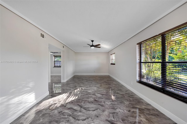 spare room featuring ceiling fan and crown molding