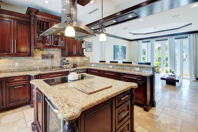 kitchen featuring black electric cooktop, kitchen peninsula, a kitchen island, and french doors