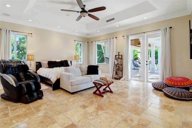 bedroom with ceiling fan, access to exterior, a tray ceiling, and multiple windows