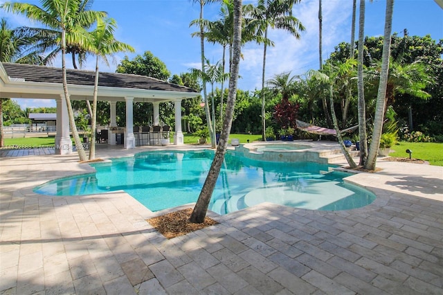 view of swimming pool featuring an in ground hot tub, an outdoor bar, and a patio