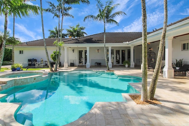 view of swimming pool with an in ground hot tub, a patio, and french doors