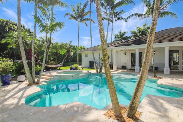 view of pool featuring a patio area, an in ground hot tub, and french doors