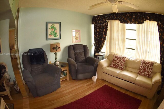 living room featuring hardwood / wood-style floors and ceiling fan