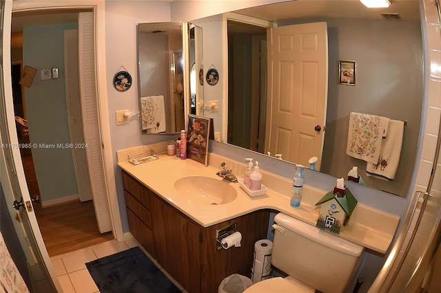 bathroom with tile patterned flooring, vanity, and toilet