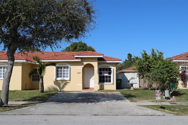 mediterranean / spanish house featuring a front lawn