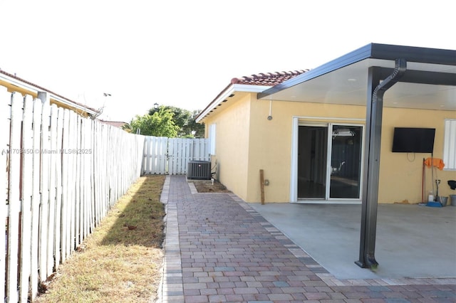 view of property exterior with cooling unit and a patio