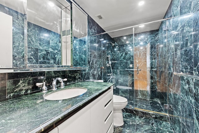 bathroom with vanity, toilet, tile walls, and walk in shower