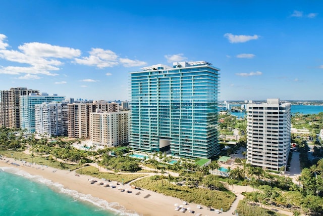 view of building exterior featuring a water view and a view of the beach