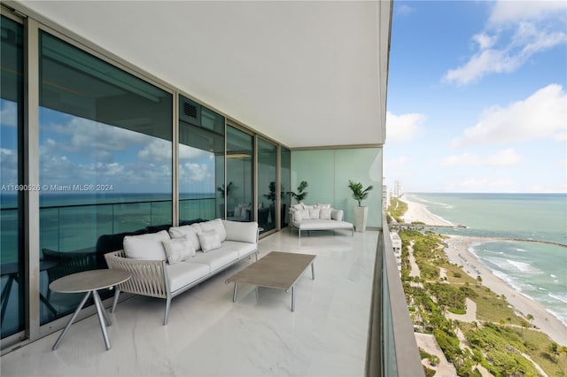 balcony featuring outdoor lounge area, a water view, and a beach view