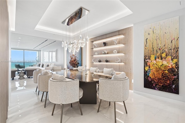 dining space featuring a water view and a raised ceiling