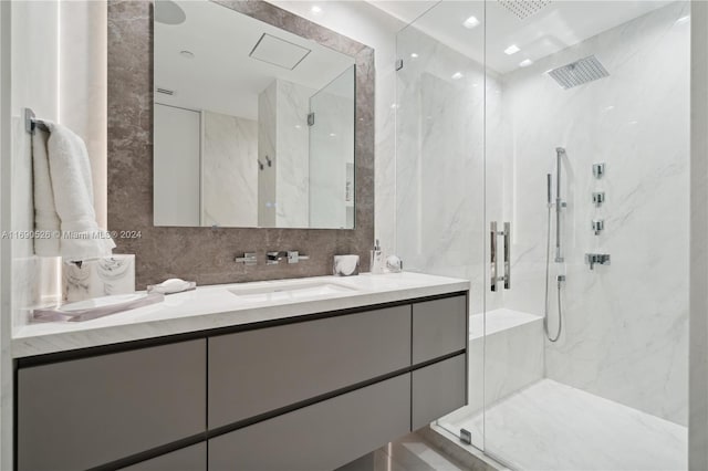 bathroom with walk in shower, vanity, tile walls, and backsplash