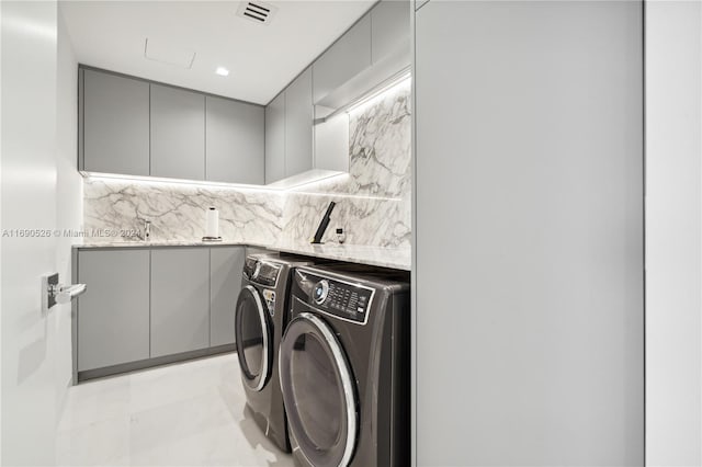 washroom with washing machine and dryer and light tile patterned floors