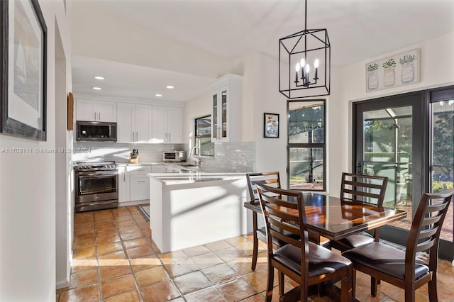 kitchen featuring white cabinets, decorative backsplash, and stainless steel appliances